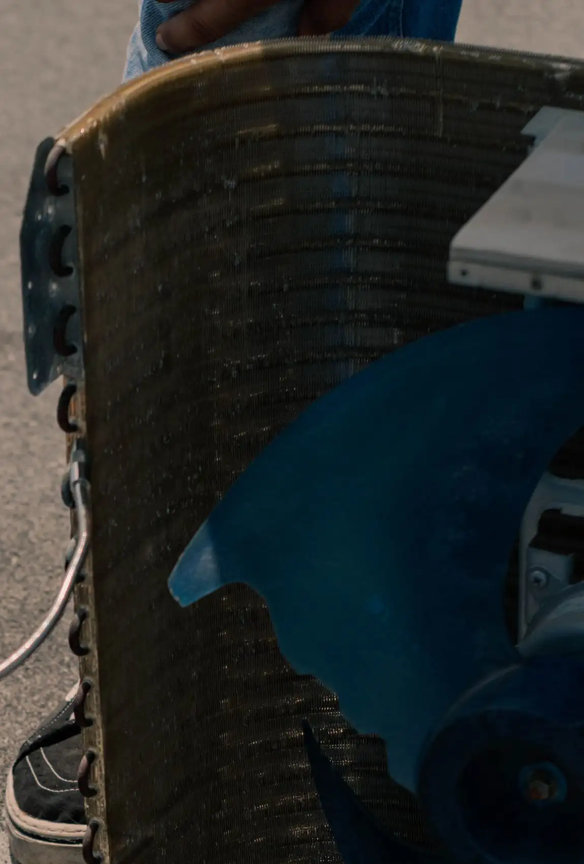 Dust-caked condenser coil and fan blade of an outdoor unit opened for service